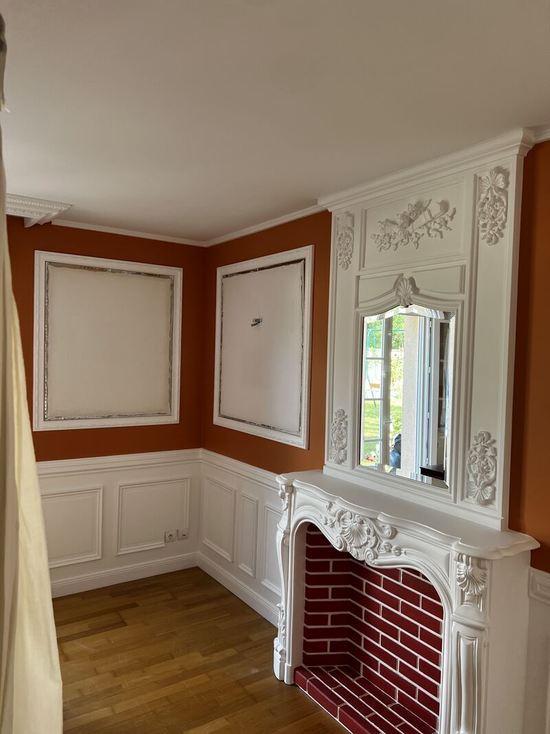 Rénovation intérieure avec moulures décoratives, cheminée et peinture terracotta