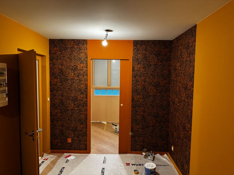 Pièce orange décorée avec un papier peint floral sombre