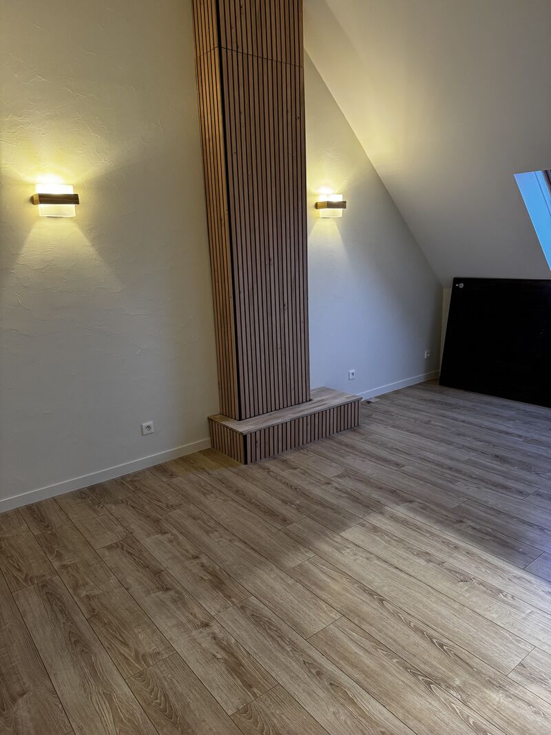 Aménagement de combles avec mur en tasseaux de bois